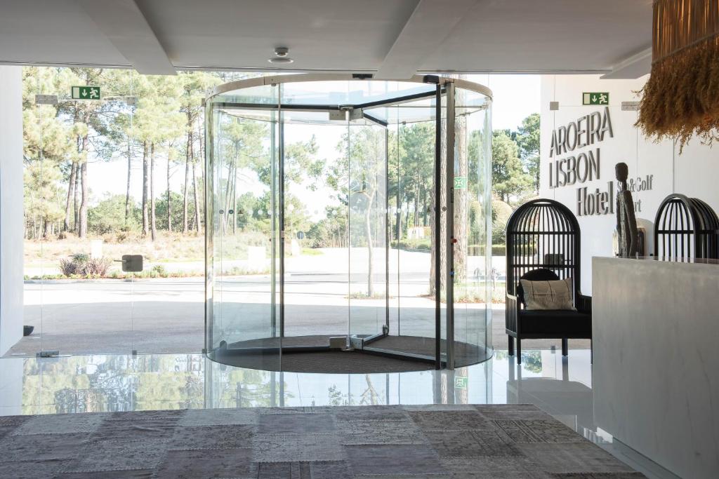a glass room with a table and a chair at Aroeira Lisbon Hotel - Sea & Golf in Aroeira