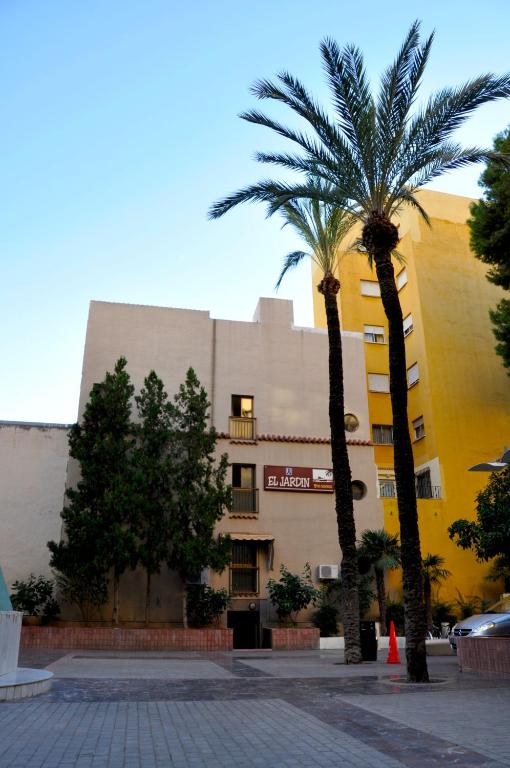 dwie palmy przed budynkiem w obiekcie Hostal El Jardín w mieście Benidorm