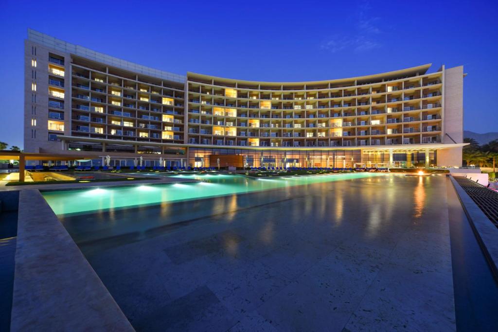 a large swimming pool in front of a large building at Kempinski Hotel Aqaba in Aqaba