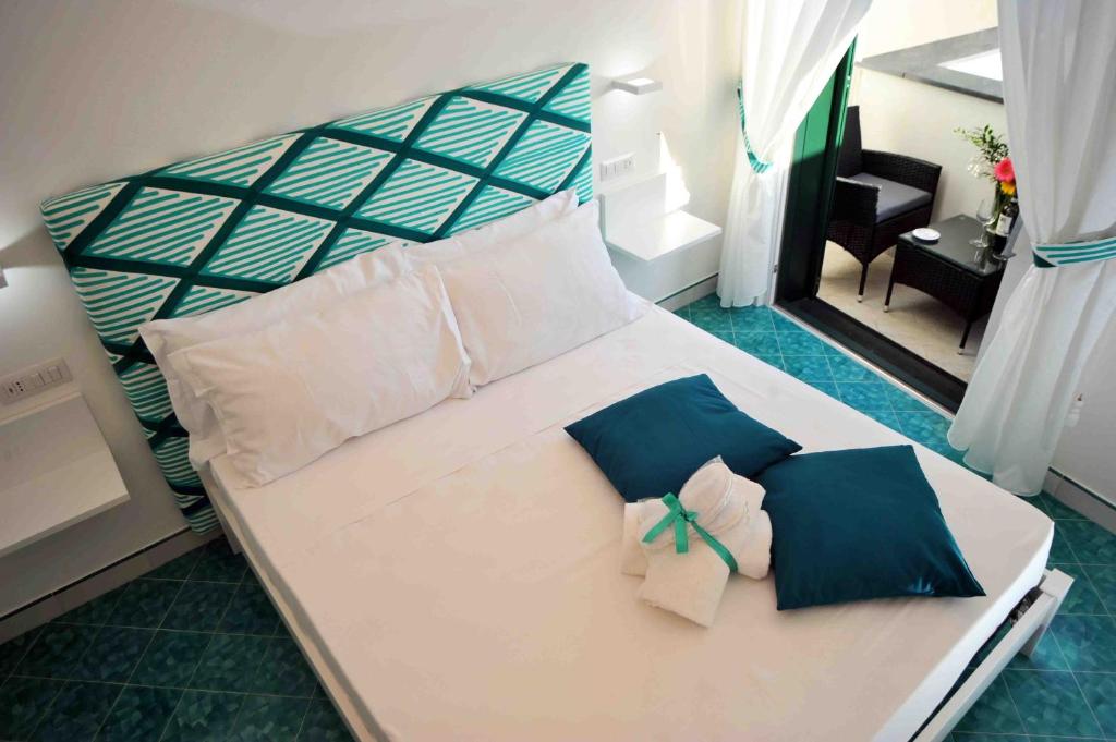 a bedroom with a large white bed with blue pillows at Matteo's House B&b in Amalfi