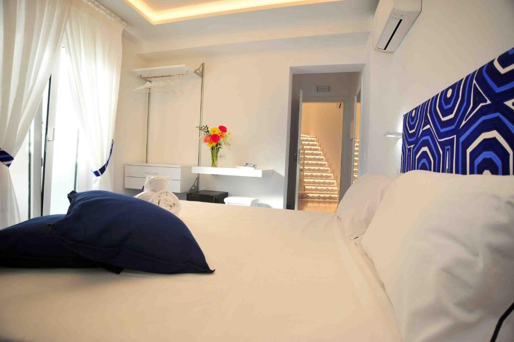 a bedroom with a white bed with a blue headboard at Matteo's House B&b in Amalfi
