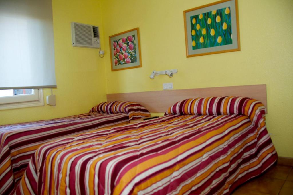Duas camas sentadas uma ao lado da outra num quarto em Hostal El Jardín em Benidorm