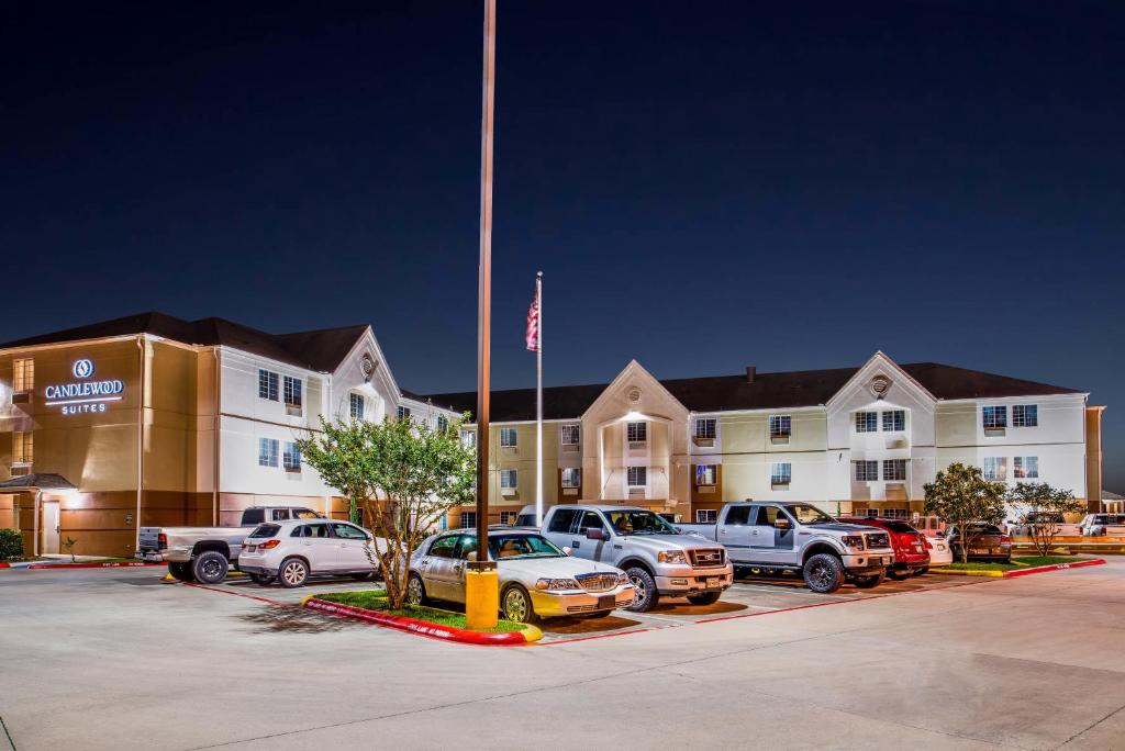 a hotel parking lot with cars parked in front of a building at Candlewood Suites Beaumont, an IHG Hotel in Beaumont