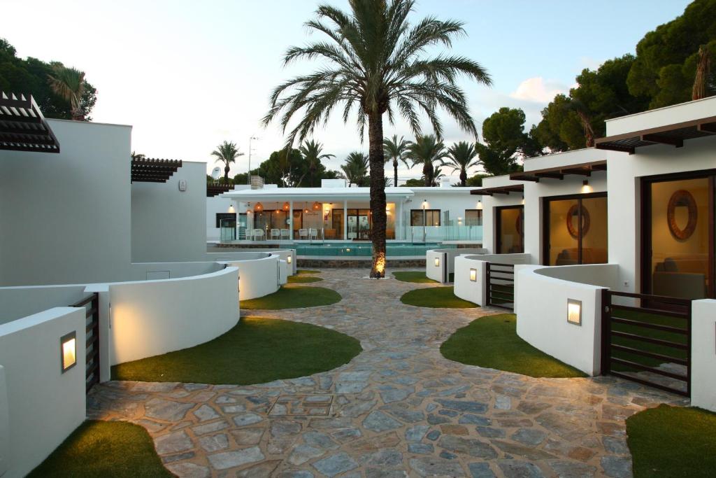 a villa with a palm tree and a swimming pool at Alidreams Carmen Beach Apartamentos in El Campello