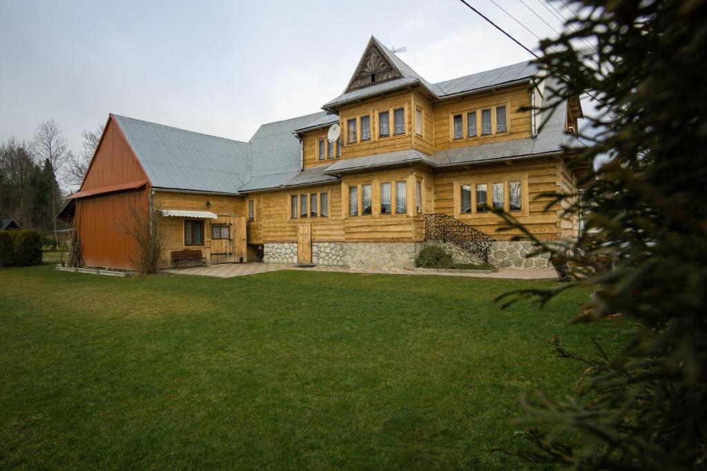 a large wooden house with a grass yard at Góralski dom Murzańskich in Białka Tatrzańska