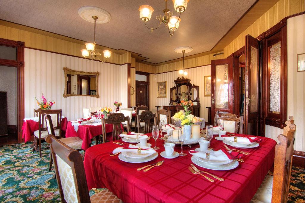 a dining room with a table with a red table cloth at Gingerbread Mansion in Ferndale