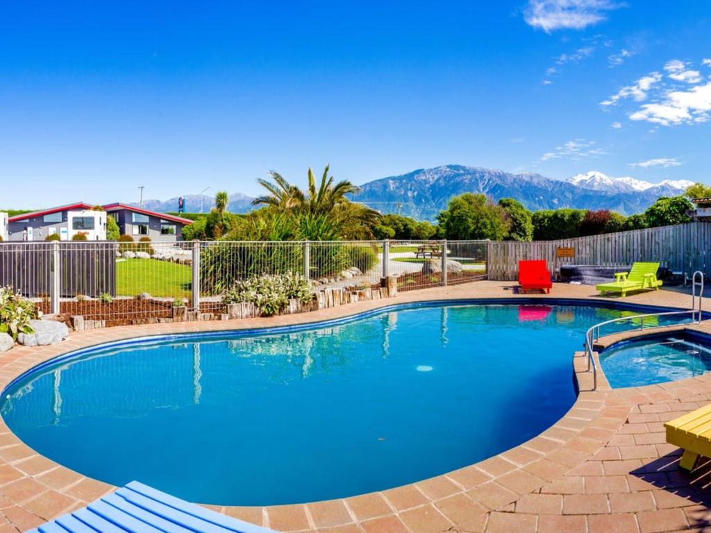 a large swimming pool with mountains in the background at Kaikoura TOP 10 Holiday Park in Kaikoura
