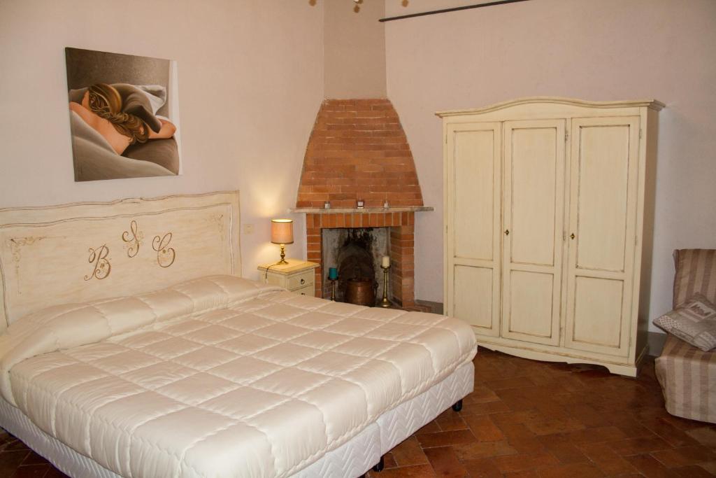 - une chambre avec un lit blanc et une cheminée dans l'établissement Santa Croce Charme Apartment, à Arezzo
