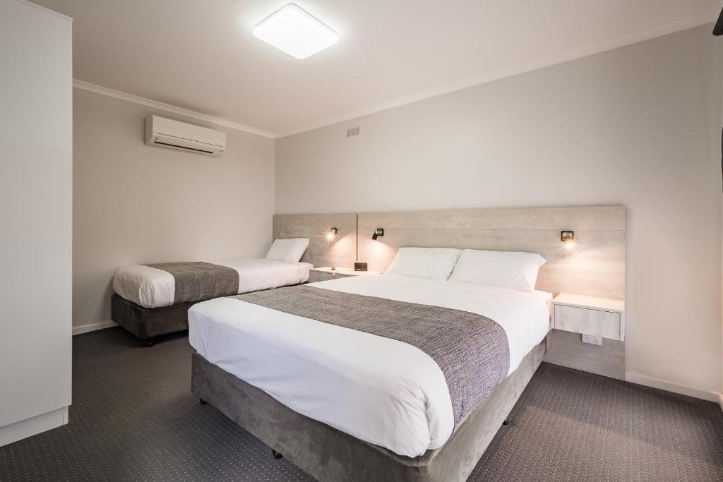 een hotelkamer met 2 bedden met witte lakens bij Seabrook Hotel in Somerset