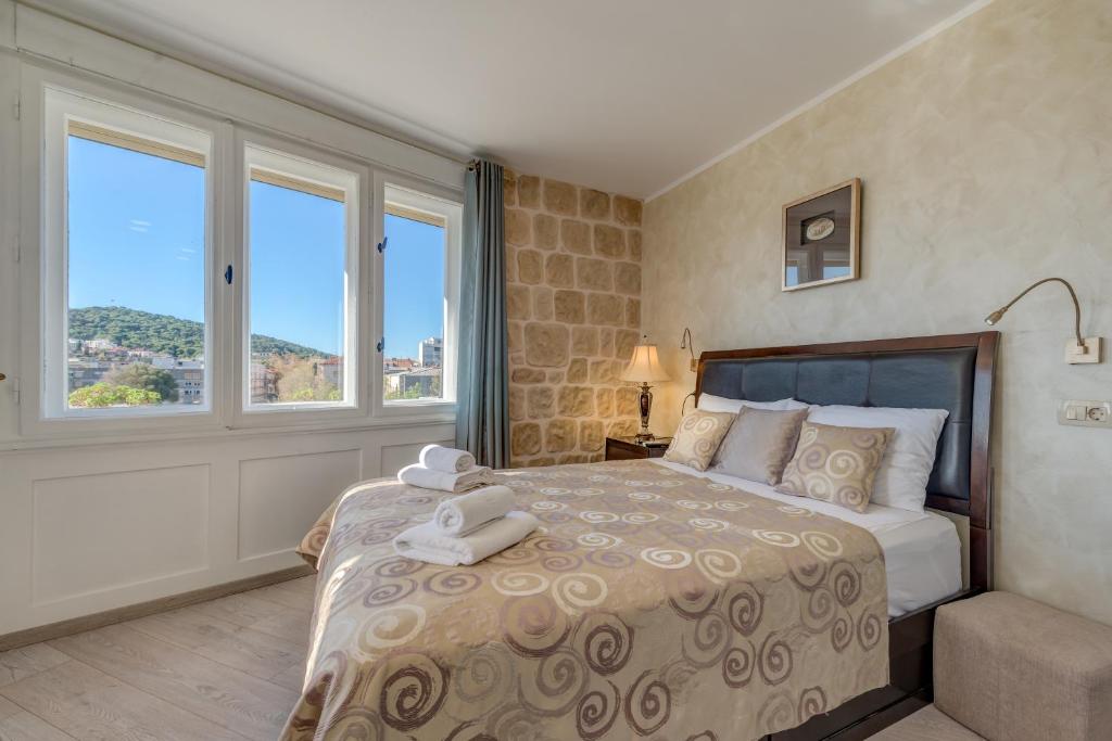 a bedroom with a large bed with a large window at Metropole Luxury Rooms in Split