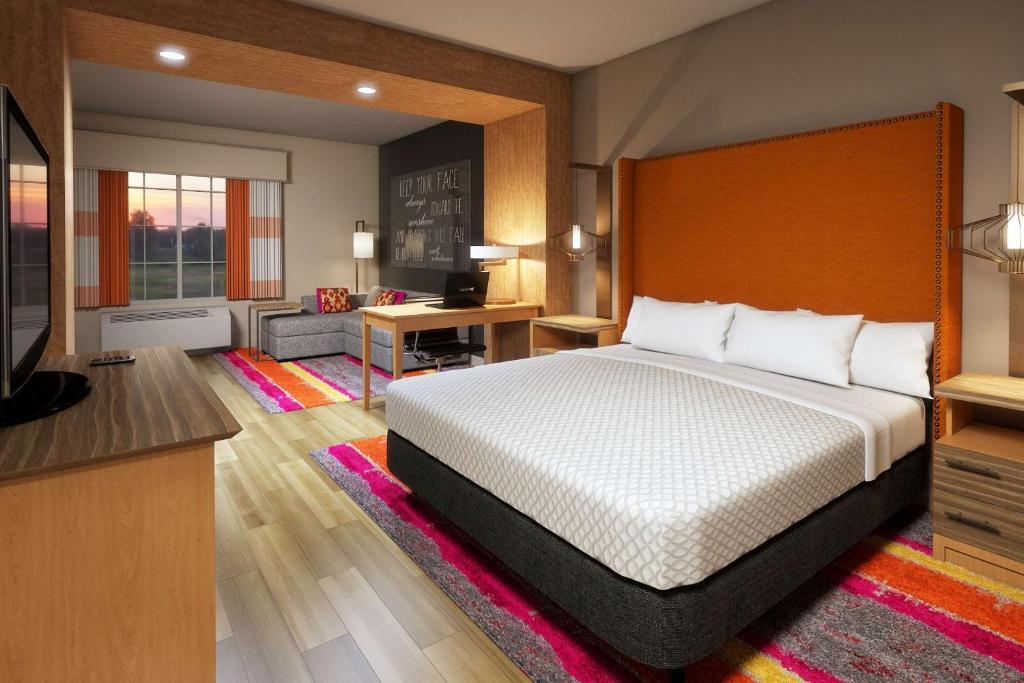 ein Hotelzimmer mit einem Bett und einem TV in der Unterkunft La Quinta Inn & Suites by Wyndham Lewisville in Lewisville
