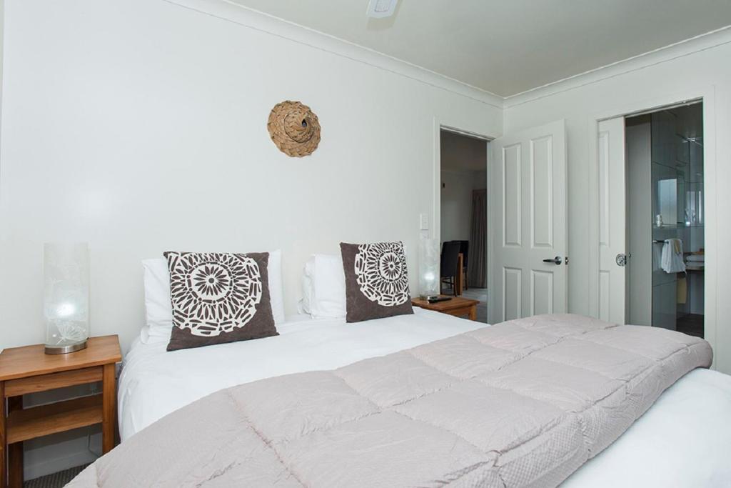 a bedroom with a large white bed with pillows at AhiKaa Gisborne Motel in Gisborne