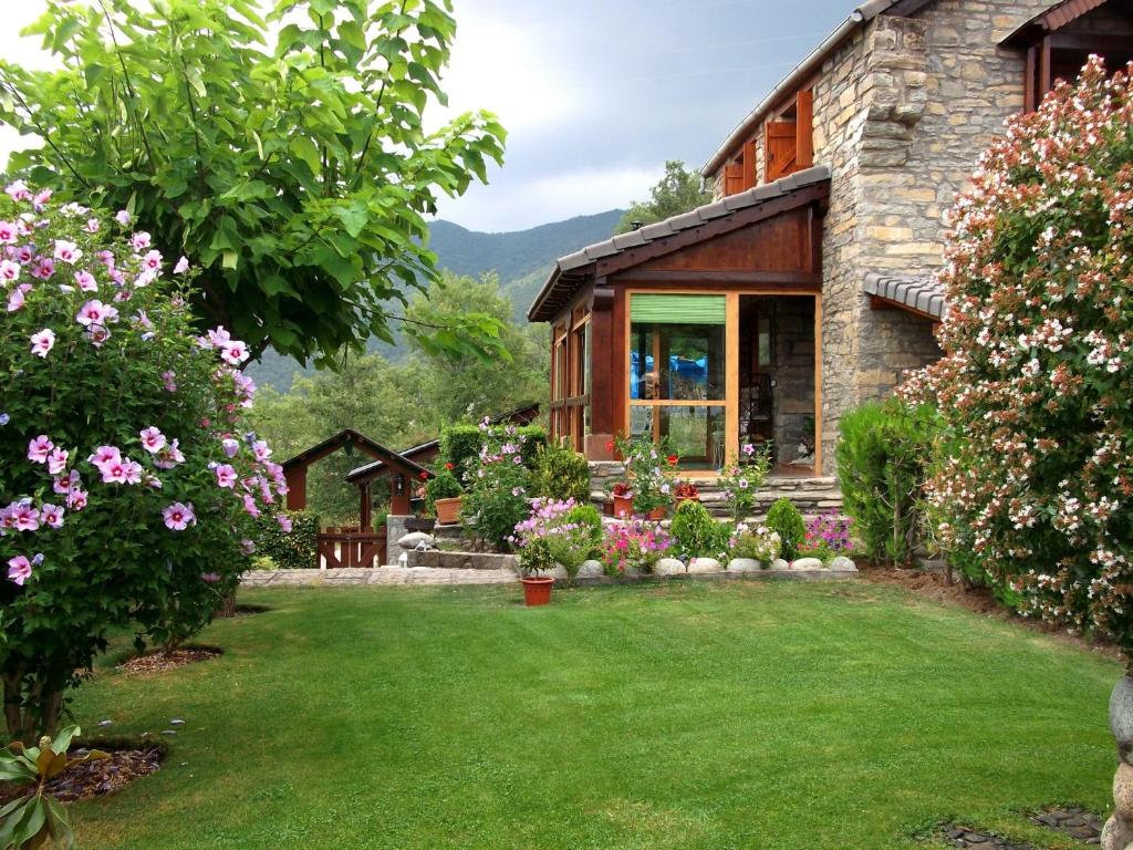 a house with a yard with flowers at Casa Rural La Era in Sieste