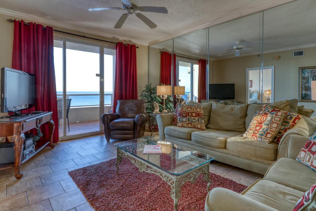 a living room with a couch and a tv at Enclave 605 in Orange Beach