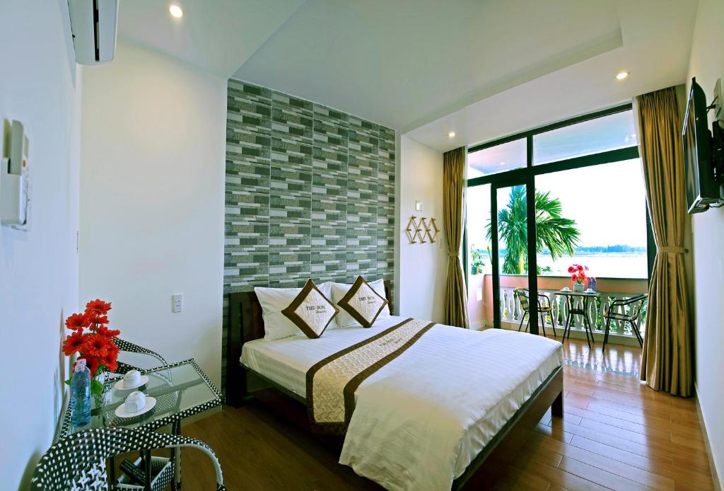 een slaapkamer met een bed met een bakstenen muur bij Thu Bon Riverside Homestay in Hội An