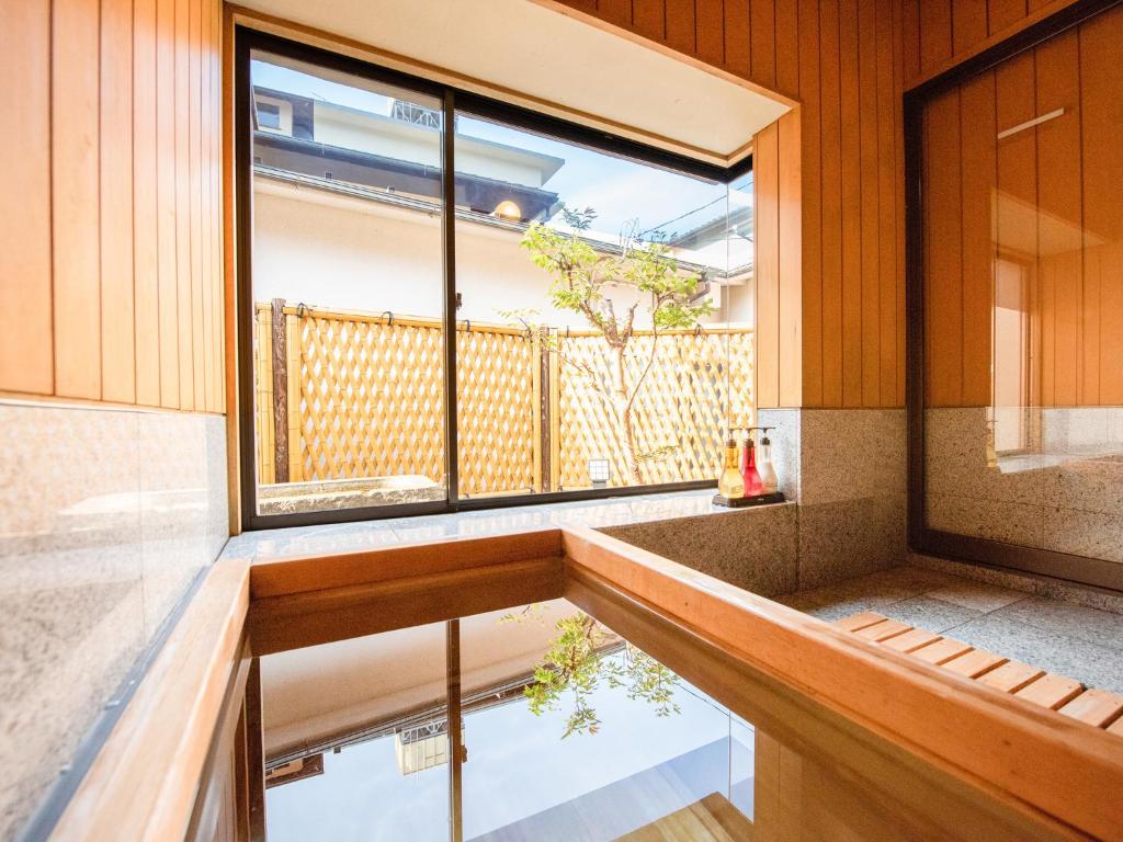 a room with a large window and a bench at Hotel Hagoromo in Shizuoka