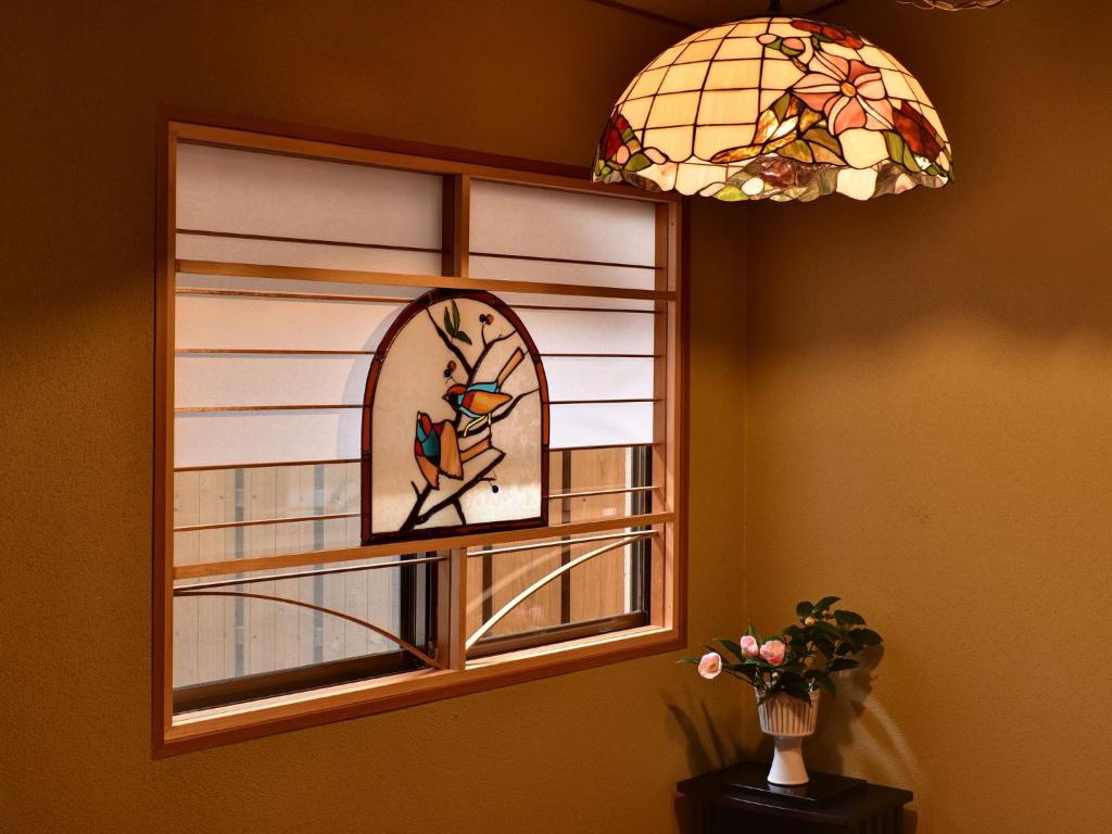 a stained glass window with a bird on a branch at Hotel Hagoromo in Shizuoka