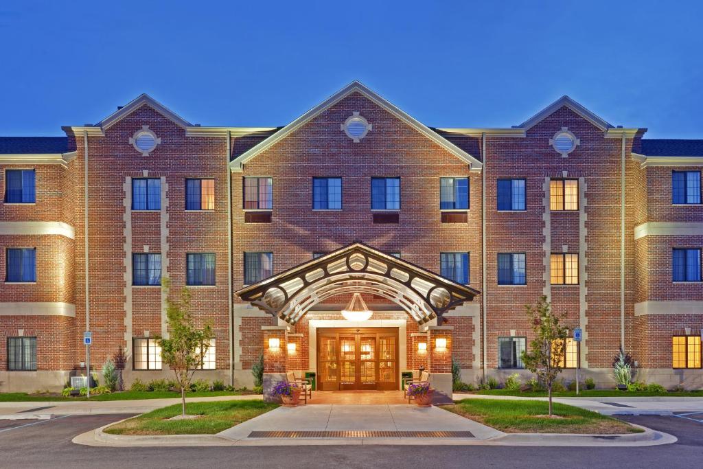 a large red brick building with a front door at Staybridge Suites Indianapolis-Carmel, an IHG Hotel in Carmel