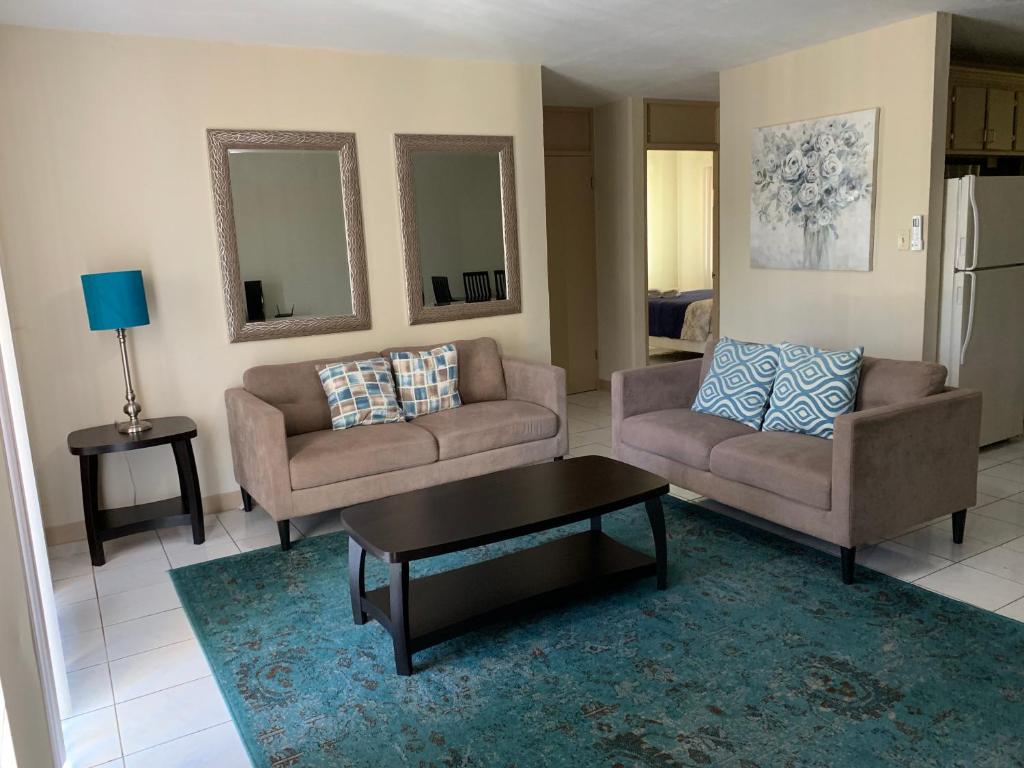 uma sala de estar com dois sofás e uma mesa de centro em Casa De Pedro- Entire Villa em Mangilao