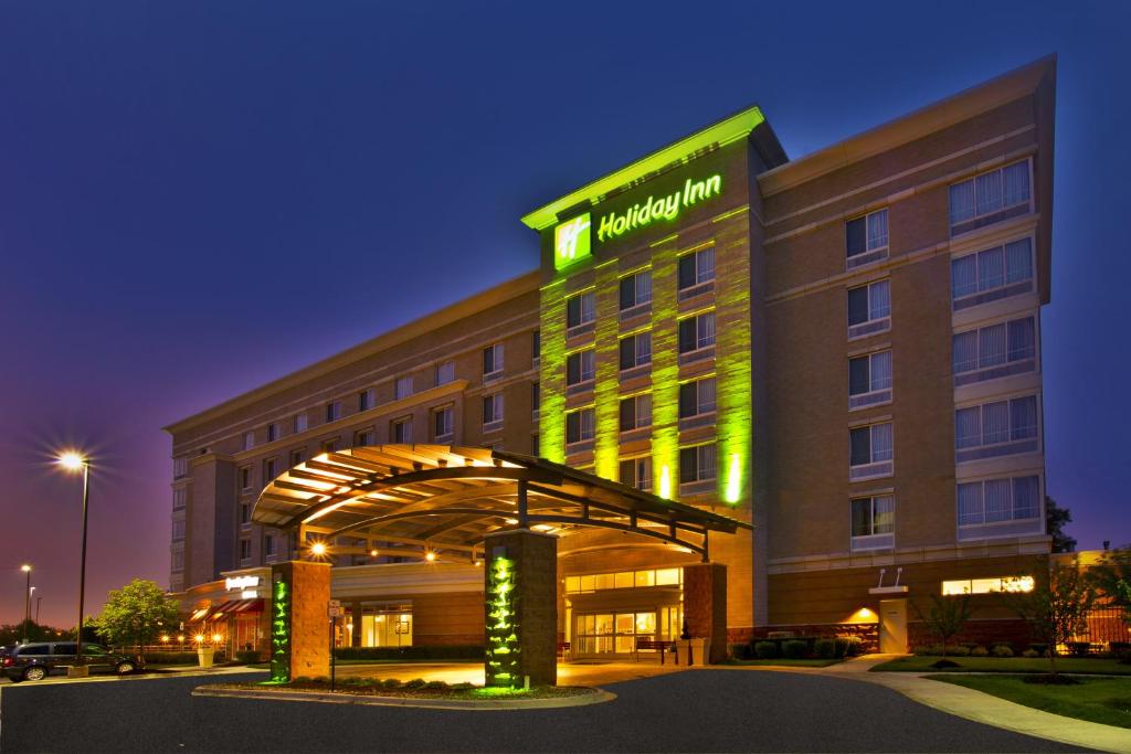 een hotelgebouw met een groen bord erop bij Holiday Inn Detroit Metro Airport, an IHG Hotel in Romulus