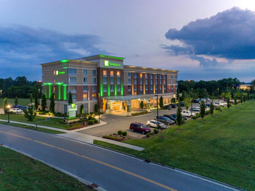 un grand bâtiment avec des lumières vertes dans un parking dans l'établissement Holiday Inn Murfreesboro, an IHG Hotel, à Murfreesboro
