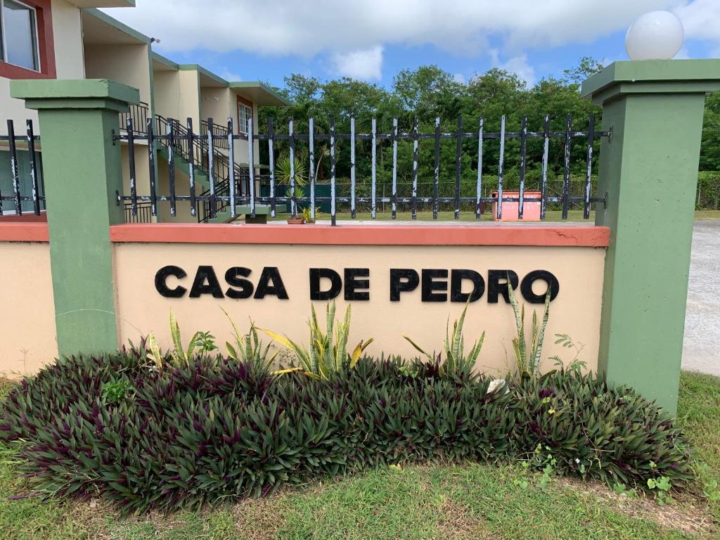 Un cartello che legge "Casa de Peoria" di fronte a una recinzione. di Entire Private Villa- Casa De Pedro a Mangilao