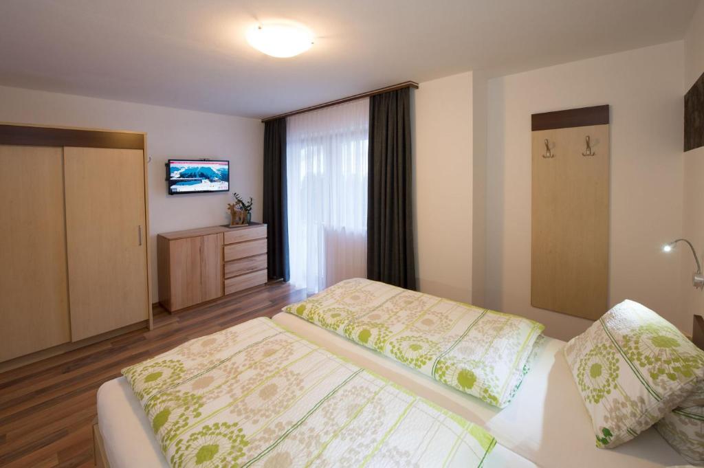 um quarto de hotel com uma cama e uma televisão em Appartement Neumayer em Viehhofen