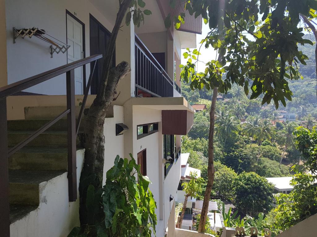 a white building with stairs and a tree at Balcony Villa in Ko Tao