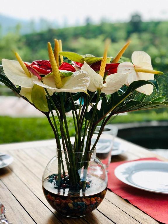 a vase filled with flowers on a table at Parisons Plantation Experiences by Abad in Mananthavady