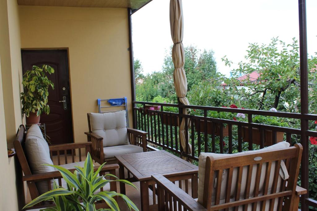 Un balcón con una silla, una mesa y una ventana en Tinikos Guest House en Telavi