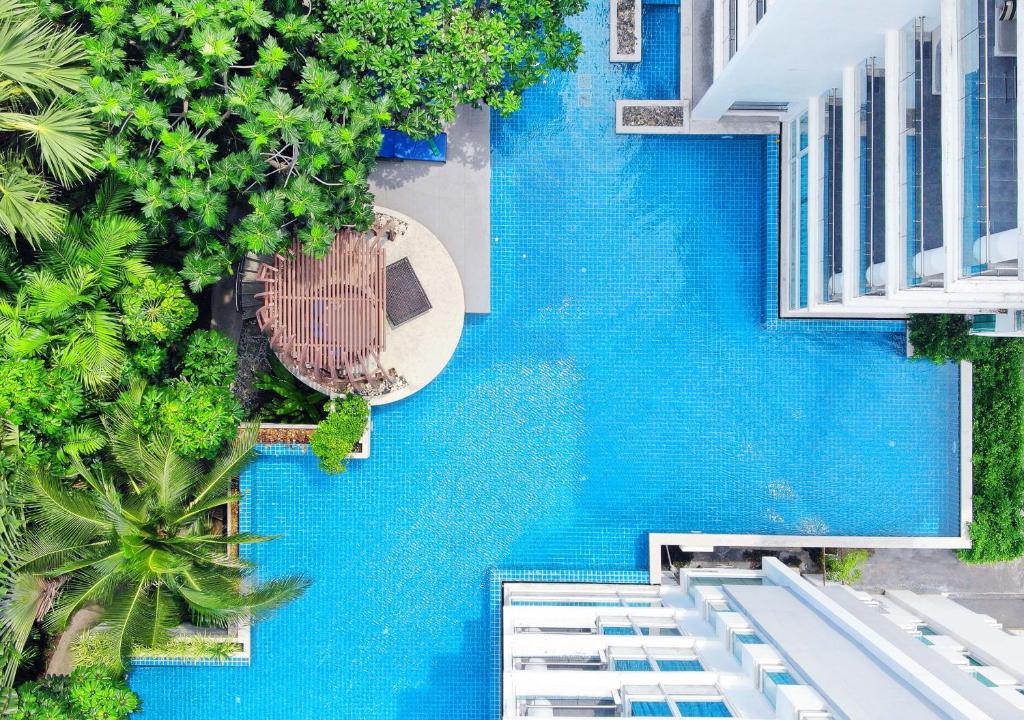 Cette chambre offre une vue sur un bâtiment bleu doté d'une piscine. dans l'établissement Mida De Sea Hua Hin - SHA PLUS, à Cha Am