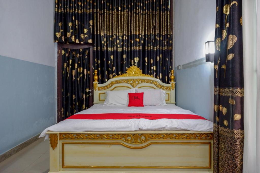 um quarto com uma cama com uma almofada vermelha em RedDoorz @ Wangi-Wangi Island Wakatobi em Mandati