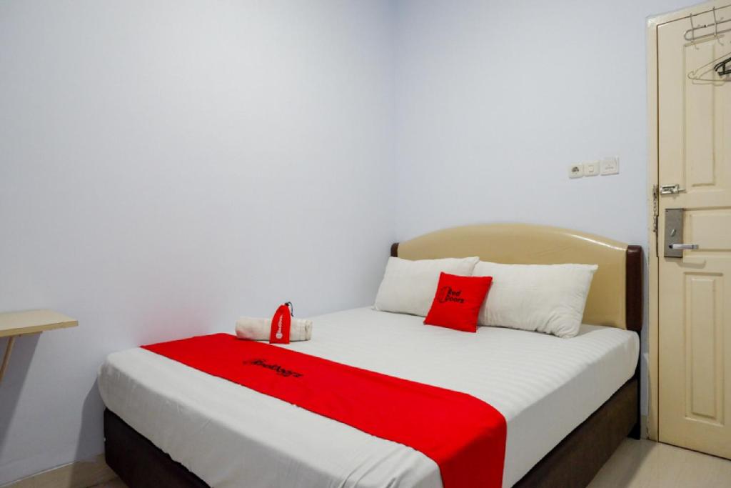 Ένα ή περισσότερα κρεβάτια σε δωμάτιο στο RedDoorz @ Hotel Bravo Pantai Kamali Bau Bau
