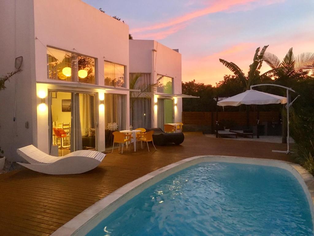 eine Villa mit einem Pool vor einem Haus in der Unterkunft Stylish Beach House with pool in Florianópolis