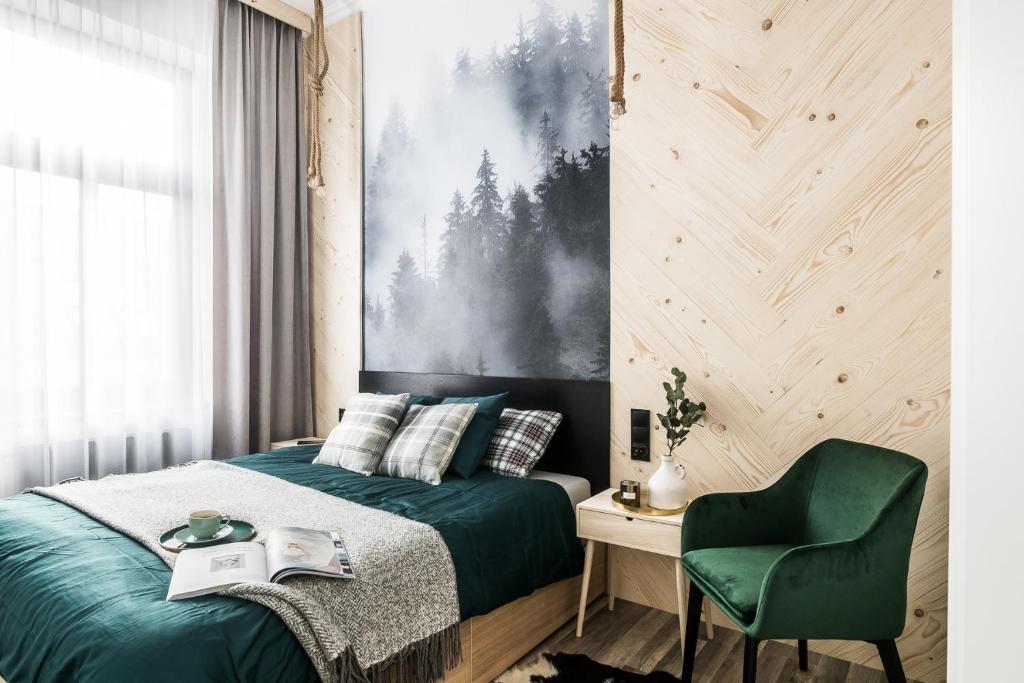 a bedroom with a green bed and a green chair at Black River Apartment in Czarny Dunajec
