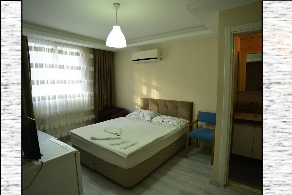 a bedroom with a bed and a blue chair at Yeşilyurt Residence in İzmir