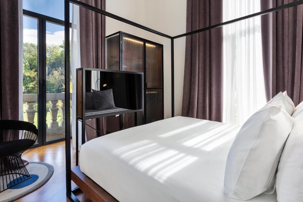 a bedroom with a bed with a tv and a window at One Shot Tabakalera House in Donostia-San Sebastián