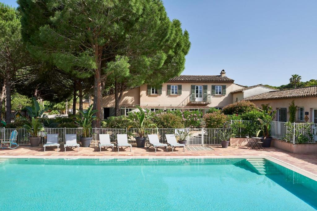 a swimming pool with lounge chairs and a house at Les Maisons Du Sud in Saint-Tropez