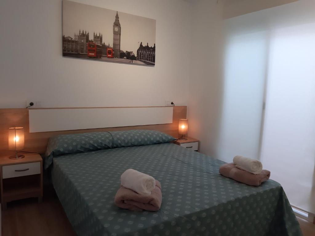 a bedroom with a bed with two towels on it at Apartamento de la huerta in Murcia