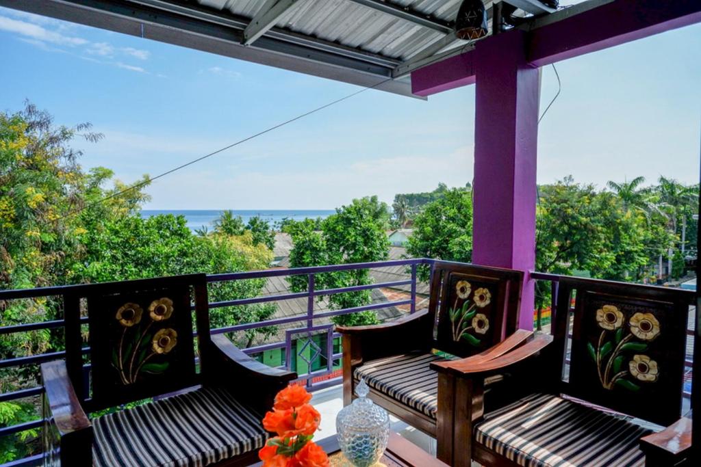 a balcony with two benches and a view of the ocean at RedDoorz @ Hotel Aulia Majene in Majene