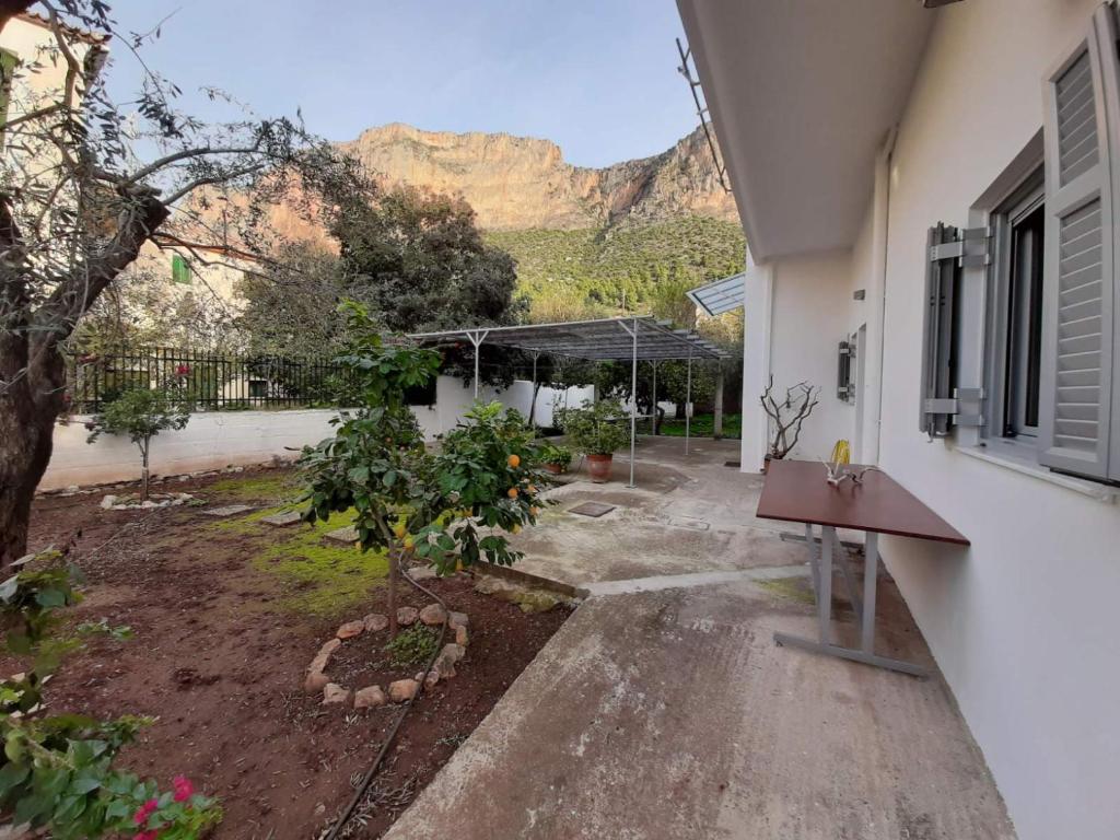 ein Haus mit einem Garten mit einem Berg im Hintergrund in der Unterkunft Garden's Home 2 in Leonidi