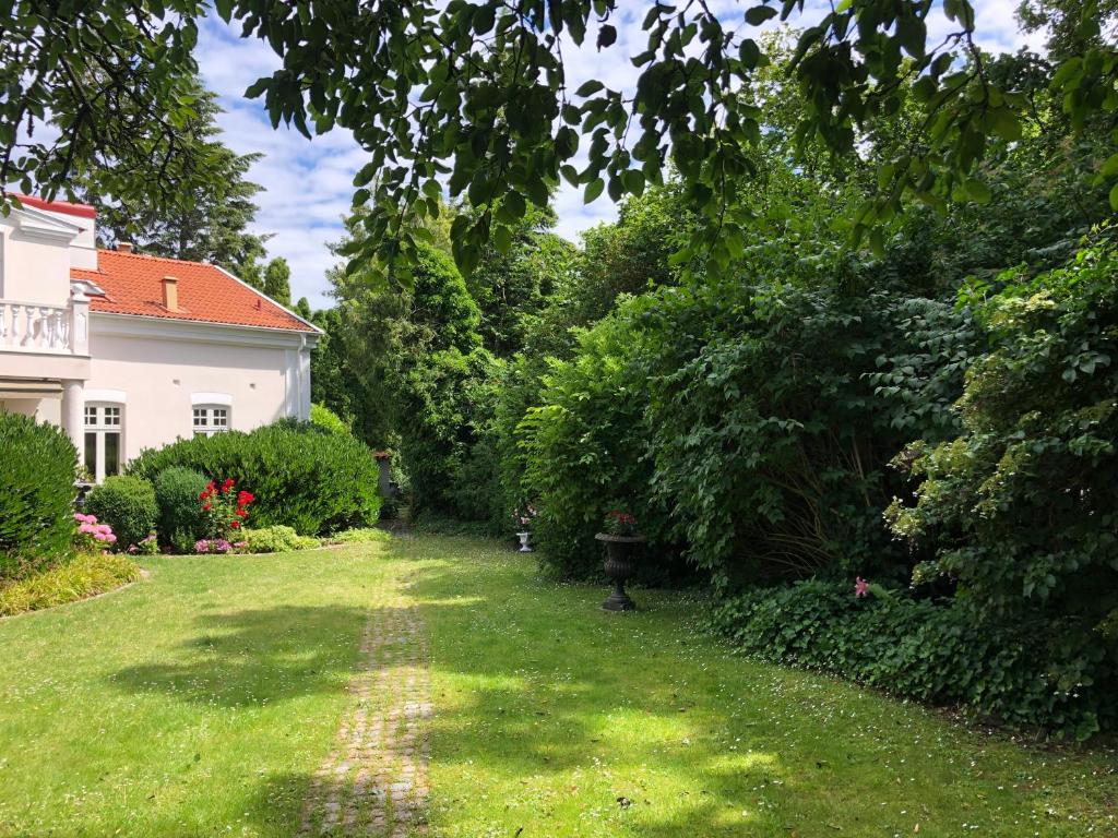 een tuin met een huis en bomen en gras bij Villa Elena in Malmö