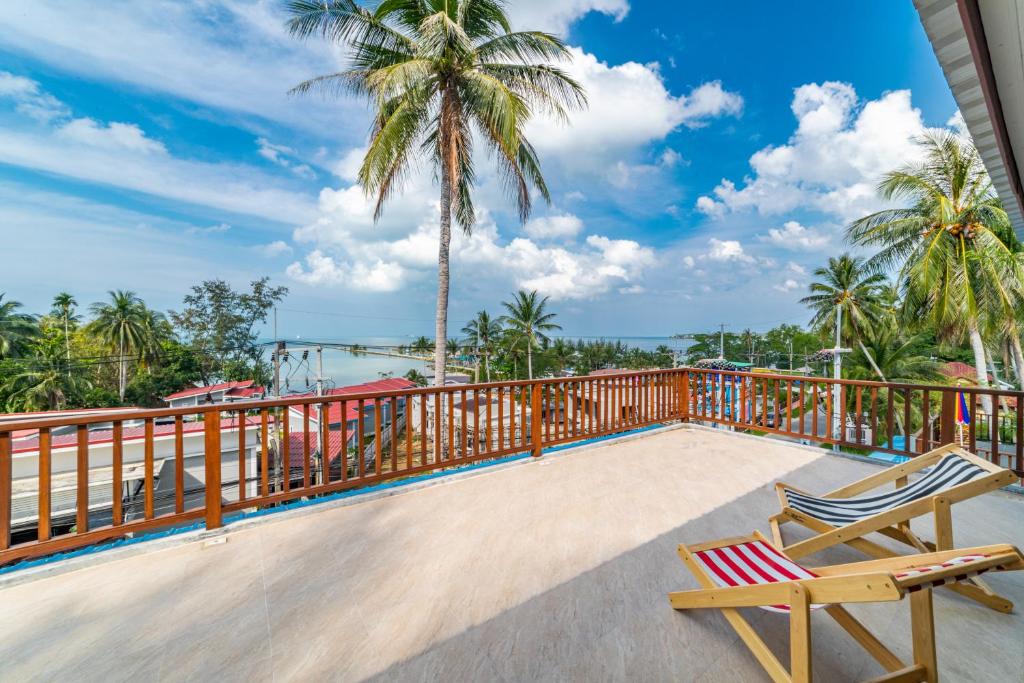 uma varanda com 2 cadeiras e vista para o oceano em Le Grand Bleu Hotel em Wok Tum
