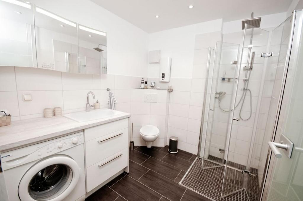 a bathroom with a washing machine and a shower at Ferienwohnung in Damp Residenzblick an der Ostsee in Damp