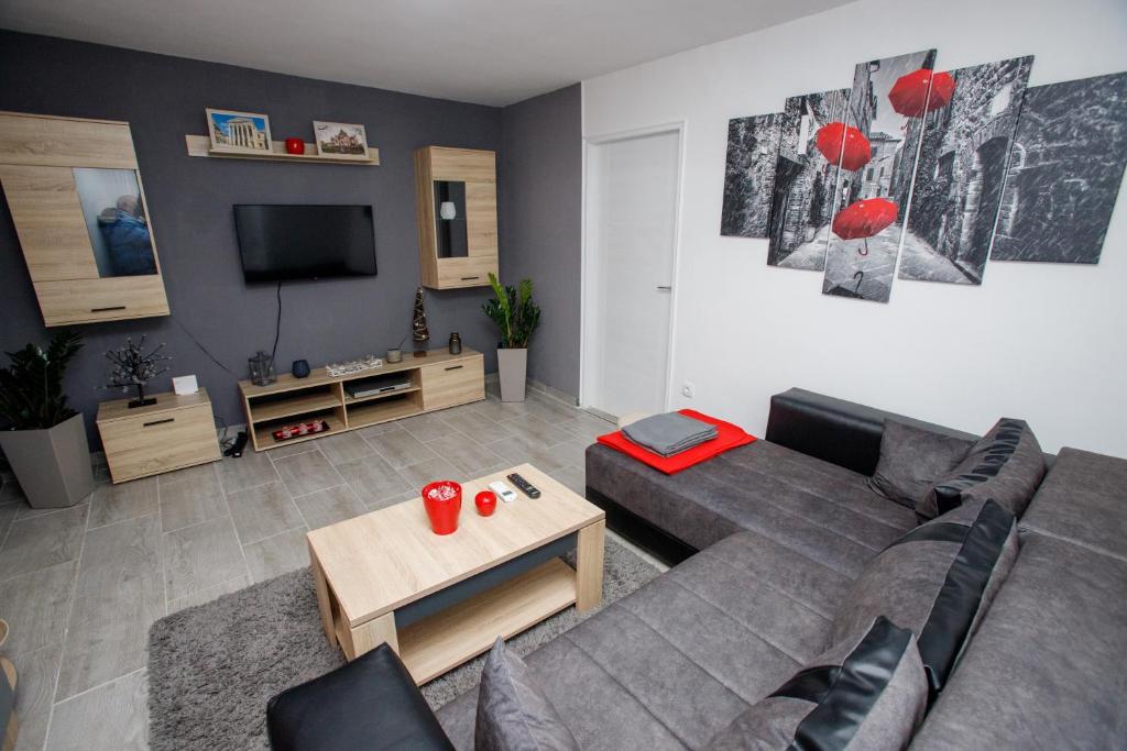 sala de estar con sofá gris y TV en 7 Days Premium Apartment en Subotica