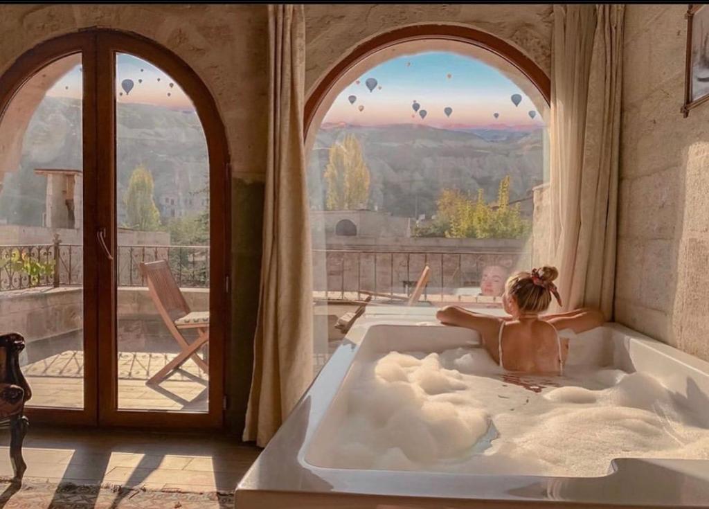 a child in a bath tub in a room with a window at Angel Cave Suite in Goreme