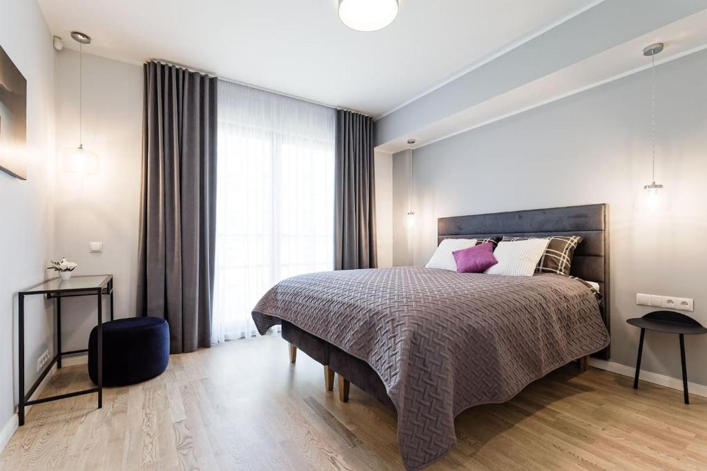 sypialnia z dużym łóżkiem i dużym oknem w obiekcie Central apartments, Quiet with Free Parking and AC. w Tallinnie
