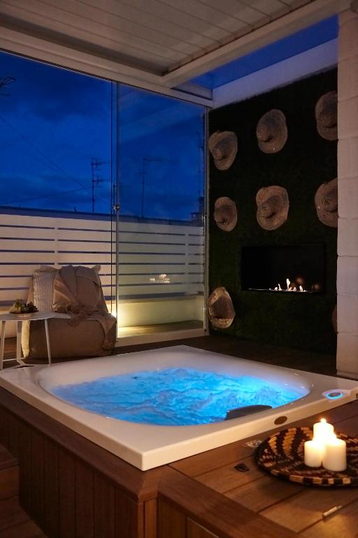 a jacuzzi tub in a room with a fireplace at Musae Relais & SPA in Polignano a Mare