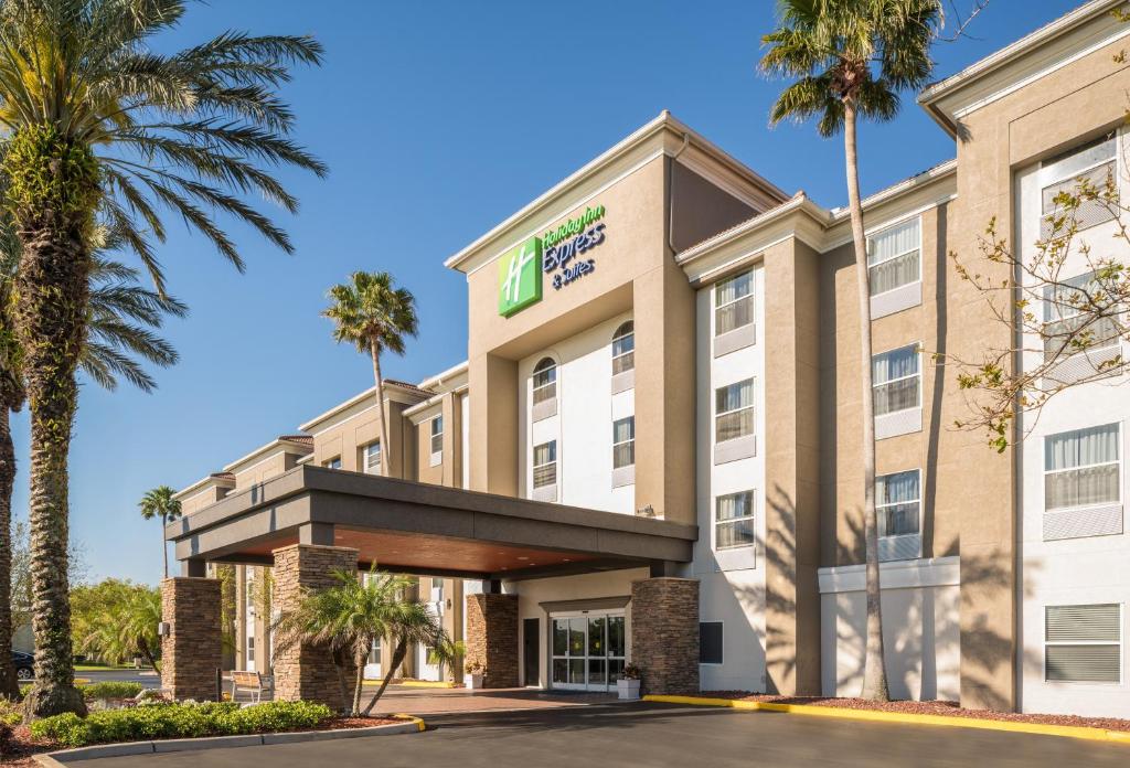 a hotel with palm trees in front of a building at Holiday Inn Express & Suites Orlando International Airport, an IHG Hotel in Orlando