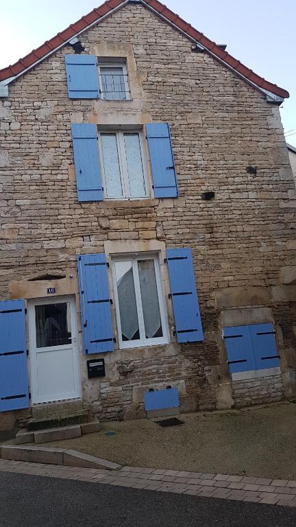 a brick building with blue shutters on it at Gîte La P'tite Louise in Les Riceys